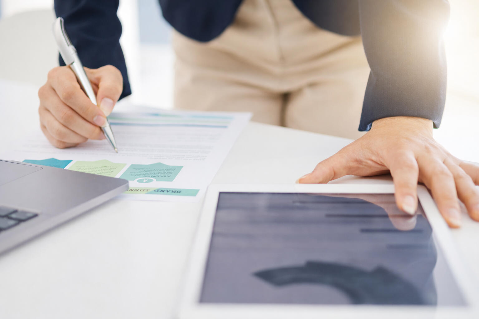 Project-Based Support Consultant reviewing business plans and reports at a desk