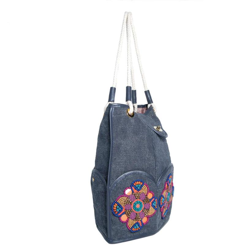 Marguerite Octagonal Bucket Bag by Havana & Co. – Distressed canvas with leather trim, six outer pockets, and handmade embellishments with sequins and beads.