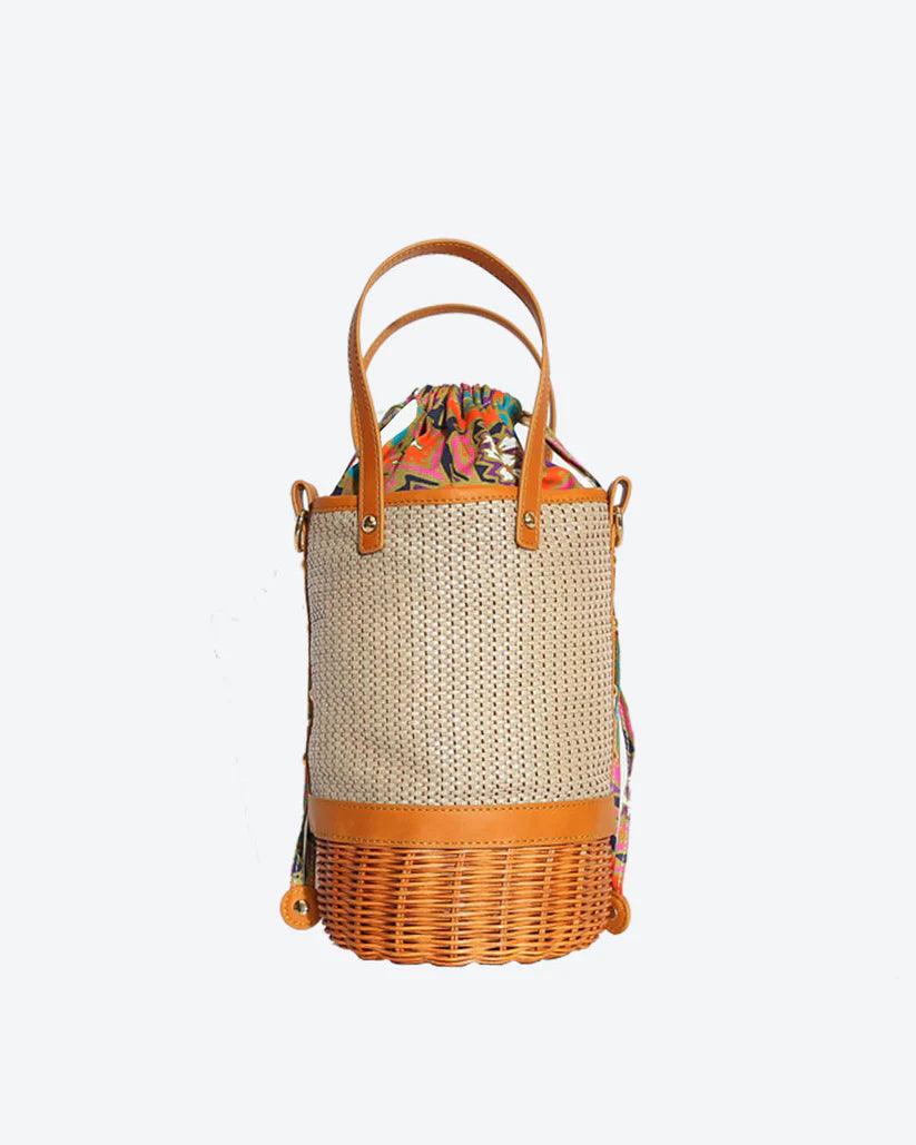 Tory Small Rattan Basket in Brown by Havana & Co. – Hand-woven rattan and raffia bag with leather details and colorful drawstring lining.