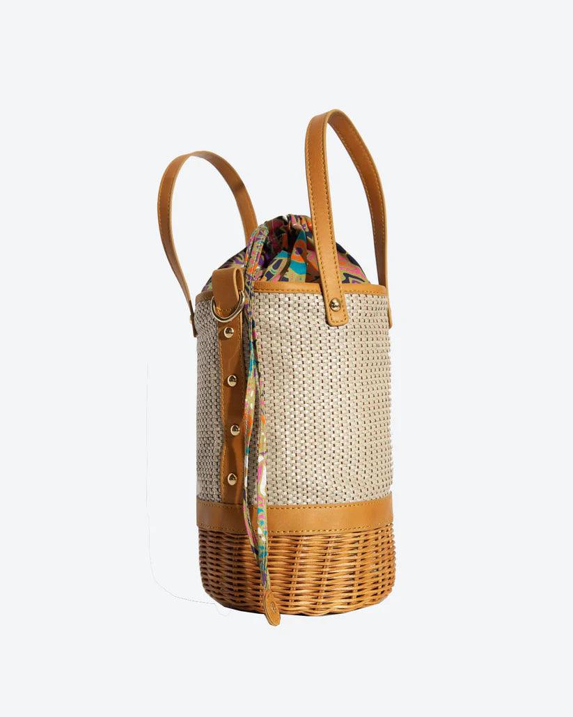 Tory Small Rattan Basket in Brown by Havana & Co. – Hand-woven rattan and raffia bag with leather details and colorful drawstring lining.