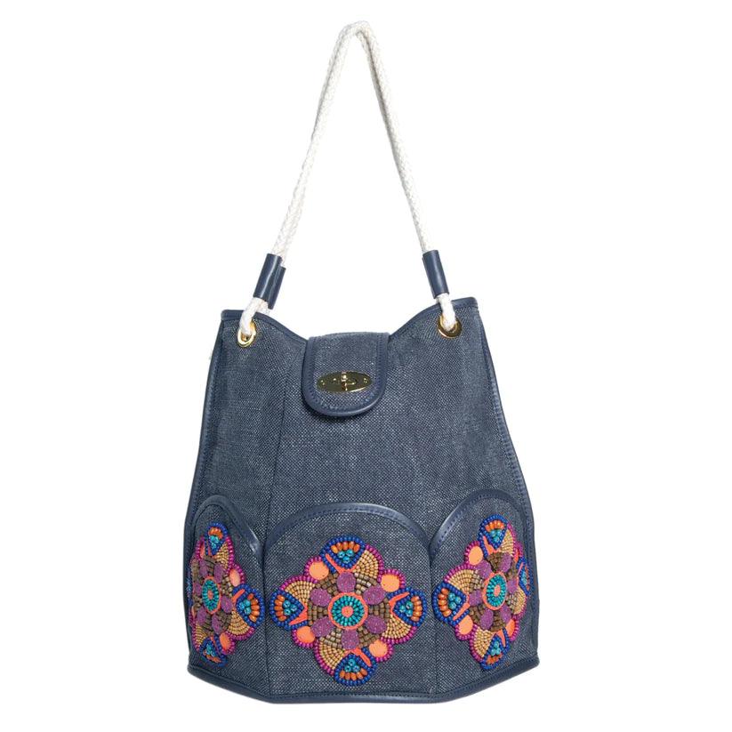 Marguerite Octagonal Bucket Bag by Havana & Co. – Distressed canvas with leather trim, six outer pockets, and handmade embellishments with sequins and beads.