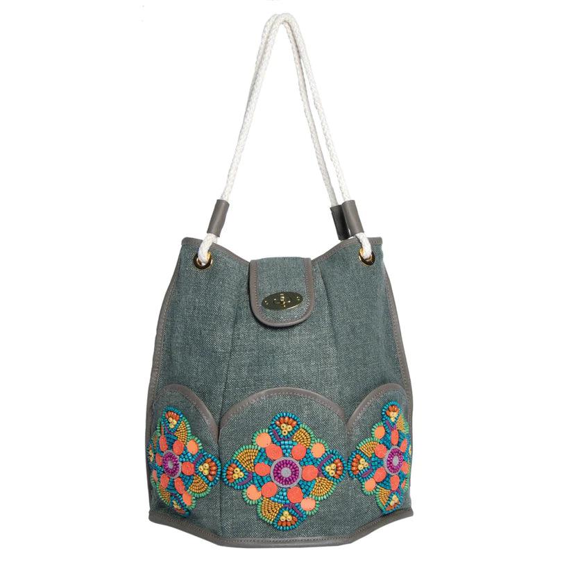 Marguerite Octagonal Bucket Bag by Havana & Co. – Distressed canvas with leather trim, six outer pockets, and handmade embellishments with sequins and beads.